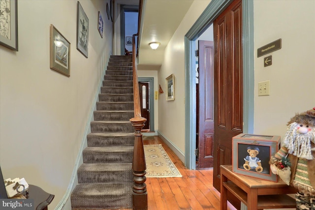 staircase featuring hardwood / wood-style flooring and baseboards