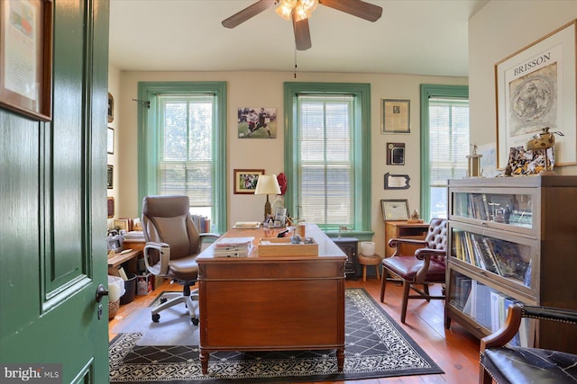 office area with ceiling fan, wood finished floors, and a healthy amount of sunlight