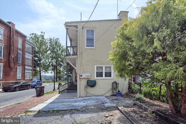 exterior space with brick siding and a balcony