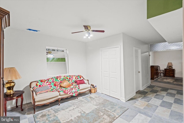 sitting room featuring a ceiling fan and baseboards