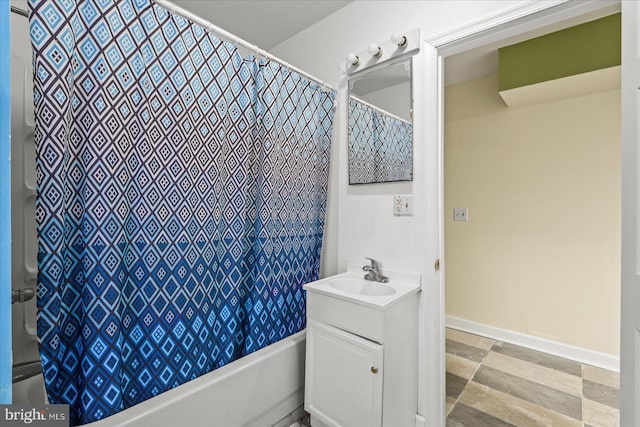 bathroom with shower / bath combo with shower curtain, vanity, and baseboards