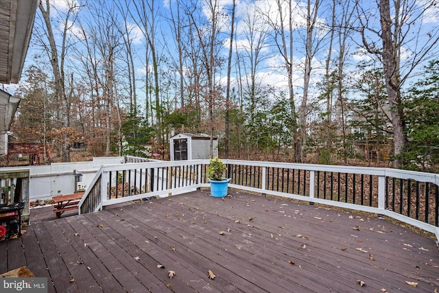 wooden deck featuring an outbuilding and a shed