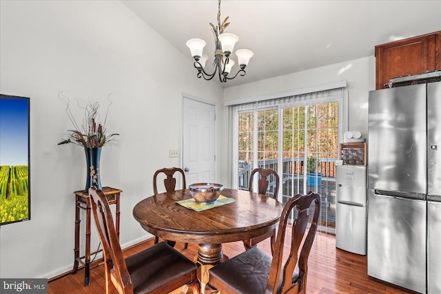 dining room with baseboards, an inviting chandelier, and wood finished floors