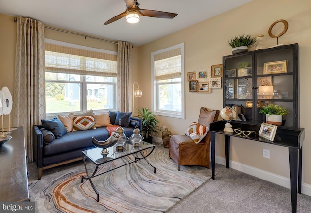carpeted living room featuring ceiling fan and baseboards