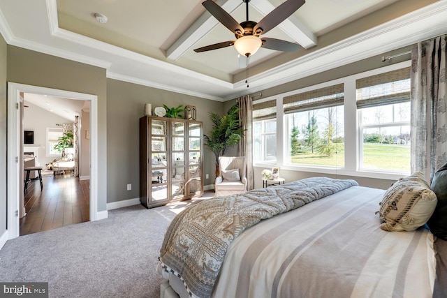 bedroom with ceiling fan, carpet flooring, baseboards, ornamental molding, and a tray ceiling