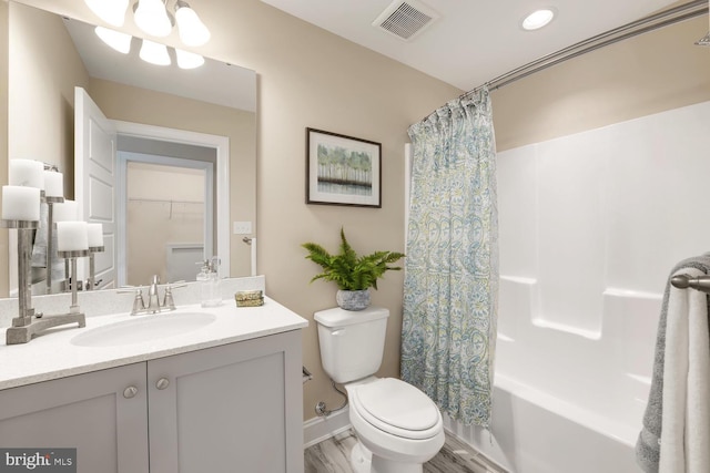 bathroom featuring toilet, visible vents, shower / bath combo with shower curtain, and vanity