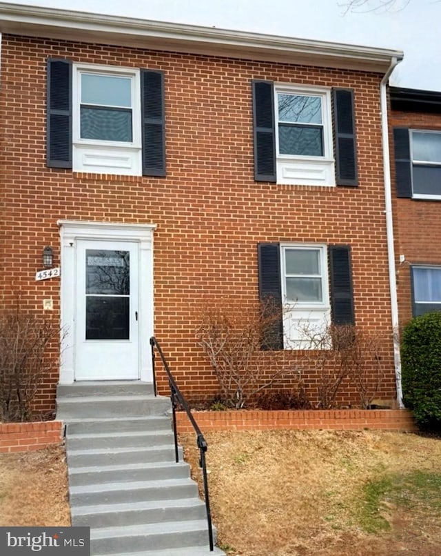 townhome / multi-family property featuring entry steps and brick siding