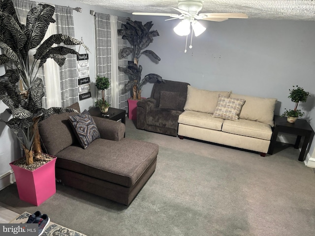 carpeted living room with a ceiling fan and a textured ceiling