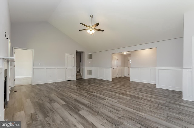 unfurnished living room featuring visible vents, stairway, ceiling fan, and wood finished floors