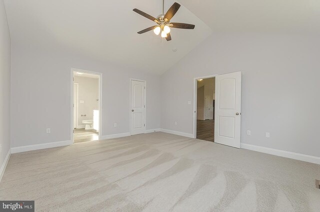 unfurnished bedroom with ceiling fan, high vaulted ceiling, light colored carpet, baseboards, and ensuite bath