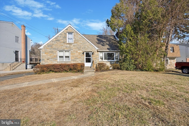 view of front facade featuring a front yard and stone siding