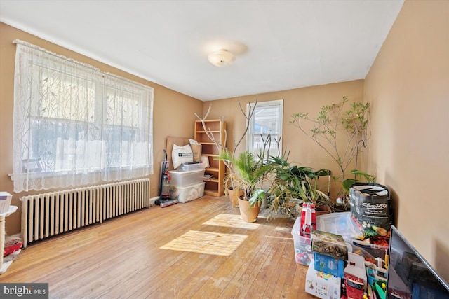 miscellaneous room with radiator heating unit and wood-type flooring