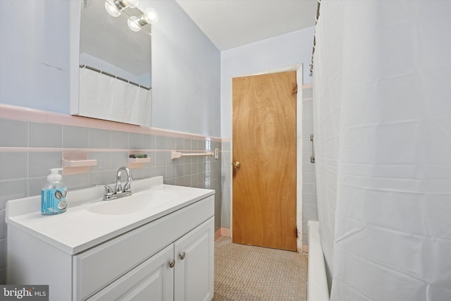 full bathroom featuring wainscoting, a shower with curtain, tile patterned floors, vanity, and tile walls