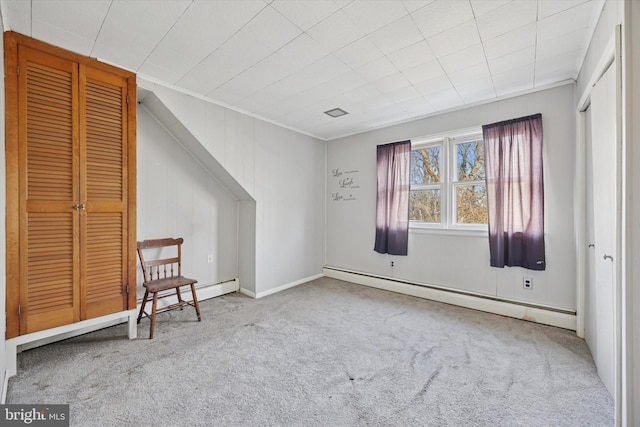 unfurnished room featuring a baseboard heating unit and carpet