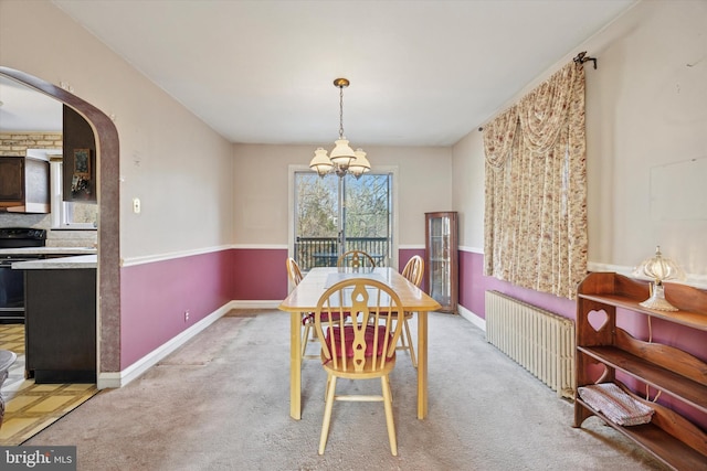 dining area with arched walkways, carpet flooring, baseboards, radiator heating unit, and an inviting chandelier