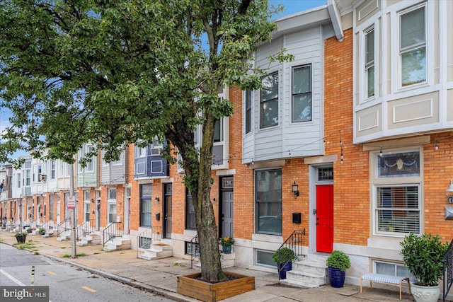 townhome / multi-family property featuring entry steps and brick siding