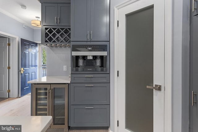 kitchen featuring light countertops, ornamental molding, gray cabinets, and oven