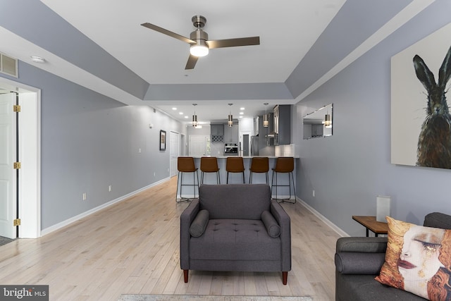 living area with recessed lighting, light wood-style floors, baseboards, and ceiling fan