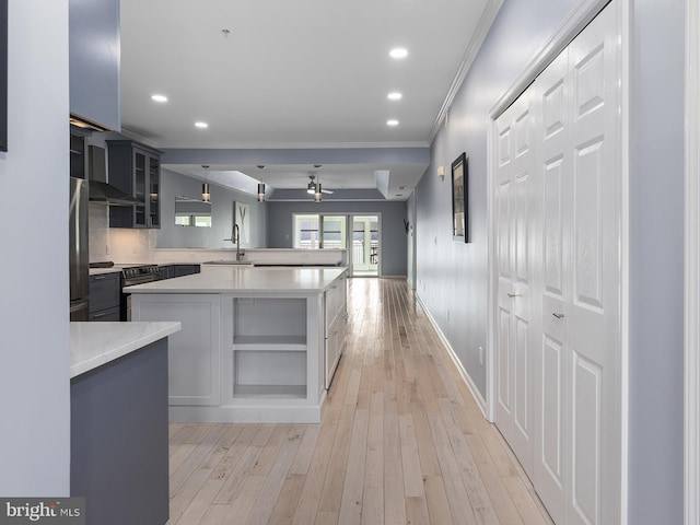 kitchen with crown molding, light wood-style flooring, freestanding refrigerator, electric range, and a sink