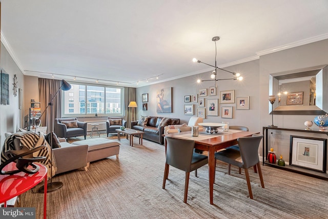 dining area with a notable chandelier, carpet flooring, rail lighting, and crown molding