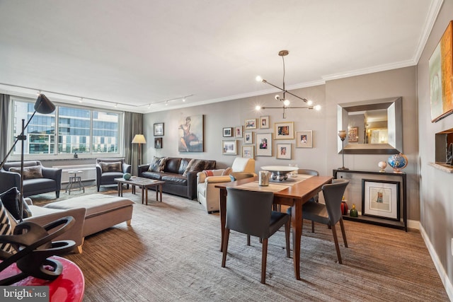 carpeted dining room featuring crown molding, track lighting, baseboards, and an inviting chandelier