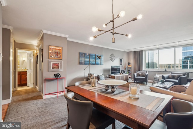 dining space featuring a chandelier, ornamental molding, rail lighting, and baseboards