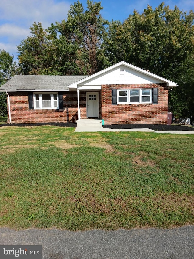 ranch-style home featuring brick siding and a front lawn