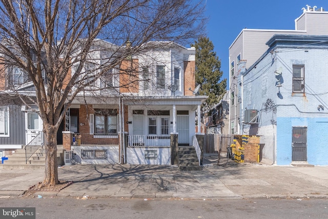 view of property with covered porch and brick siding