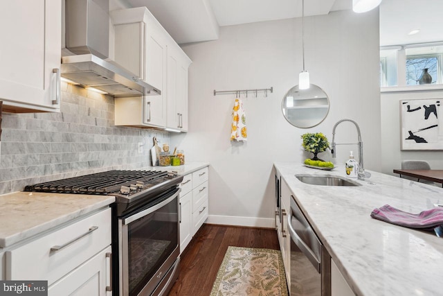 kitchen with light stone counters, a sink, appliances with stainless steel finishes, wall chimney exhaust hood, and tasteful backsplash