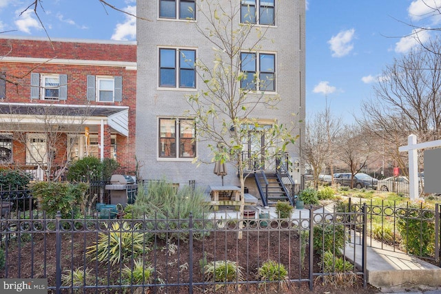 view of front of house with brick siding and fence private yard