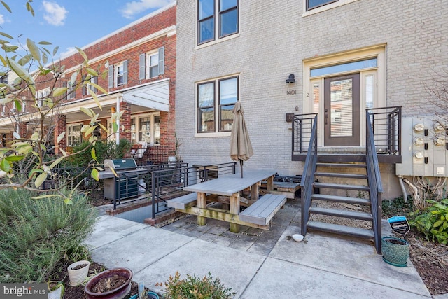 entrance to property with a patio area and brick siding