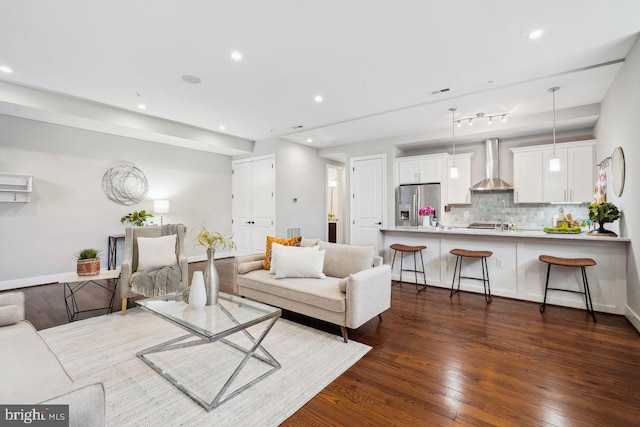 living room with dark wood-style floors, visible vents, recessed lighting, and baseboards