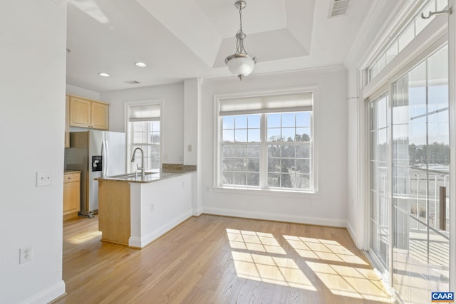 kitchen featuring visible vents, stainless steel fridge with ice dispenser, light wood-style flooring, a peninsula, and light brown cabinetry