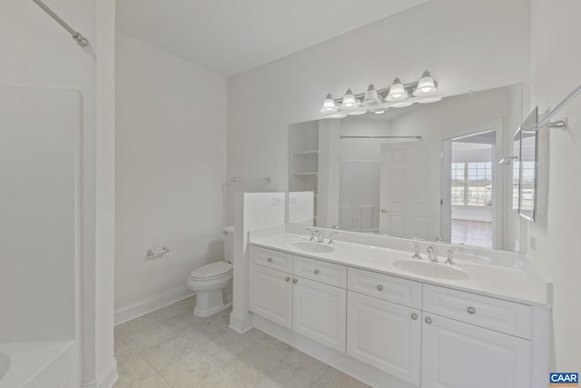 full bath with baseboards, a sink, toilet, and double vanity