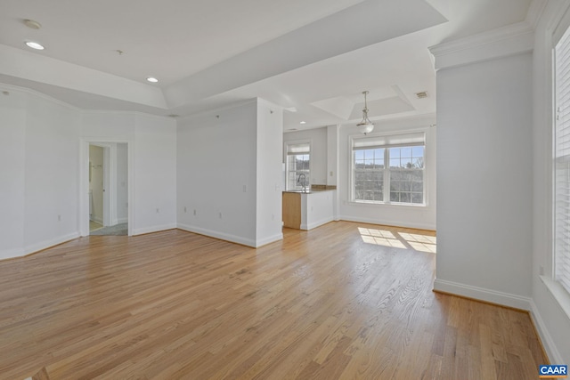 unfurnished living room with recessed lighting, a sink, baseboards, light wood-style floors, and a raised ceiling