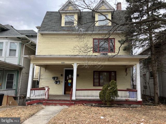 traditional style home with covered porch and a chimney