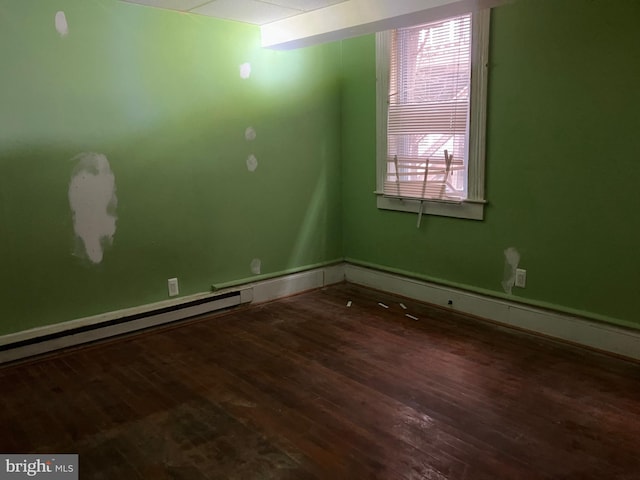 empty room featuring a baseboard radiator and wood finished floors