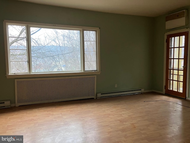 empty room featuring radiator, baseboard heating, and wood finished floors