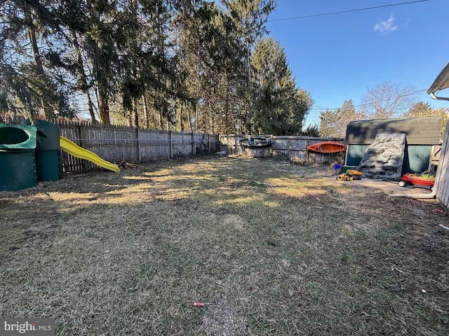 view of yard featuring a fenced backyard and a playground