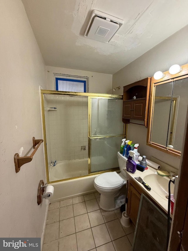 bathroom with tile patterned floors, toilet, vanity, and bath / shower combo with glass door