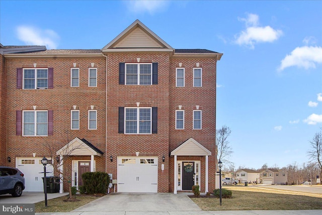 multi unit property with a garage, concrete driveway, brick siding, and a front yard