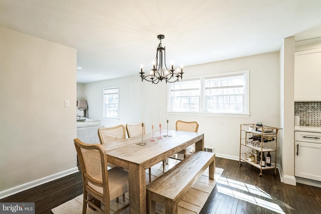 dining area featuring dark wood finished floors, visible vents, an inviting chandelier, and baseboards