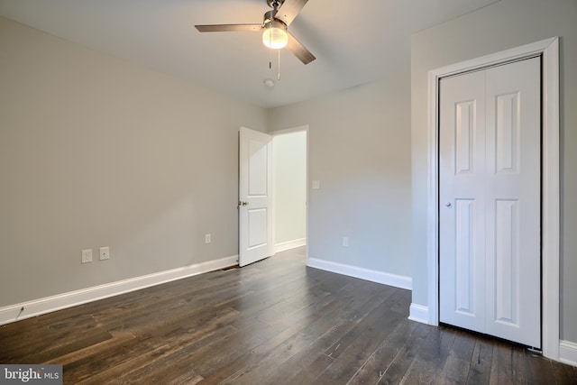 unfurnished bedroom featuring dark wood finished floors, a ceiling fan, and baseboards