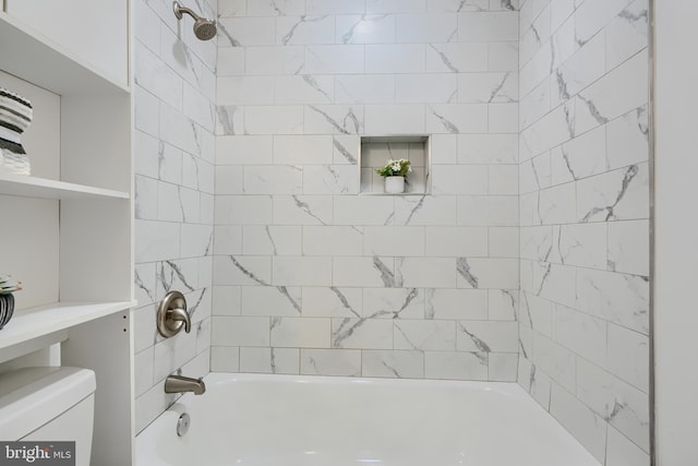 bathroom featuring tub / shower combination and toilet