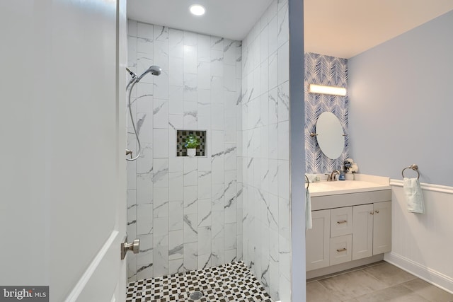 bathroom featuring vanity, baseboards, and a tile shower