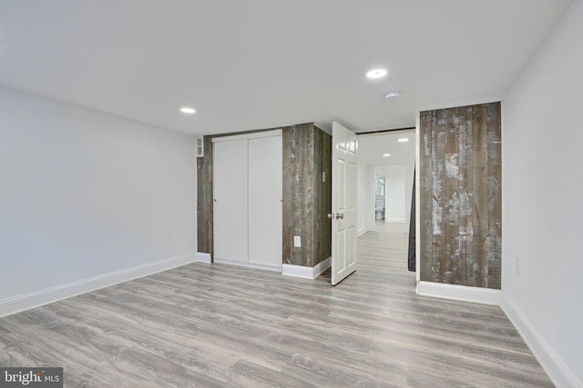 unfurnished bedroom featuring a closet, recessed lighting, baseboards, and wood finished floors