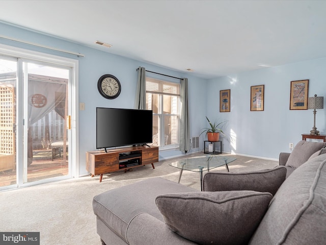 living room with carpet flooring, baseboards, and visible vents