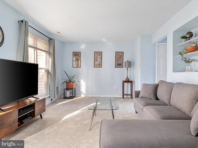 living area with visible vents, baseboards, and carpet flooring