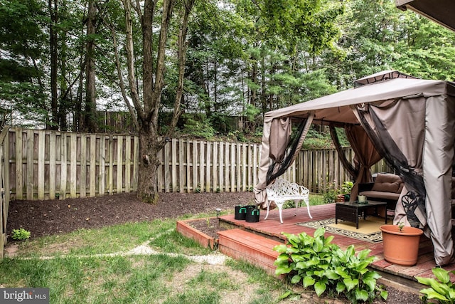 view of yard featuring a deck, a gazebo, and a fenced backyard