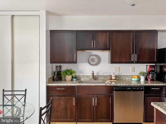 kitchen featuring dishwasher, dark brown cabinets, light stone countertops, and a sink